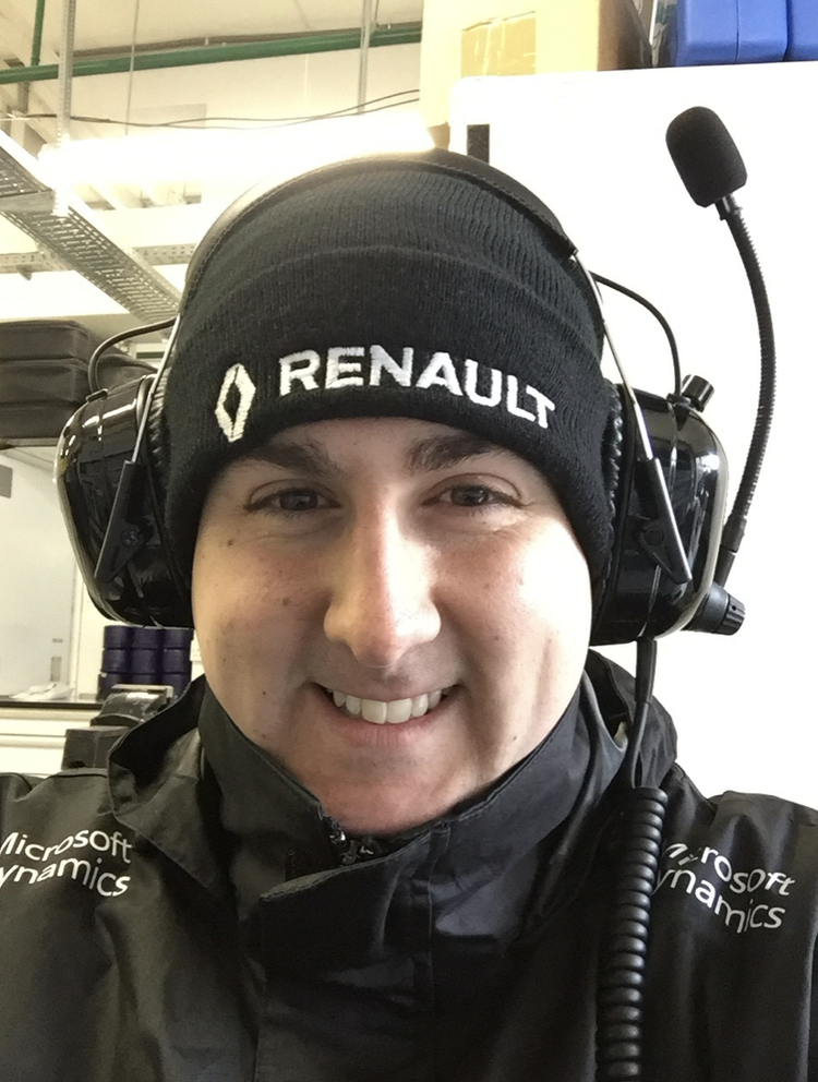 Karl Nicholson wearing a Renault hat and communications headset in a garage