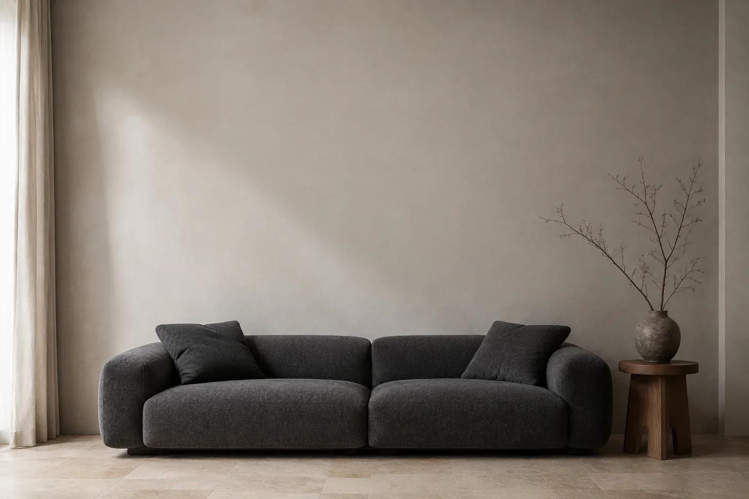 Illustrative room with a charcoal sofa against a neutral wall.