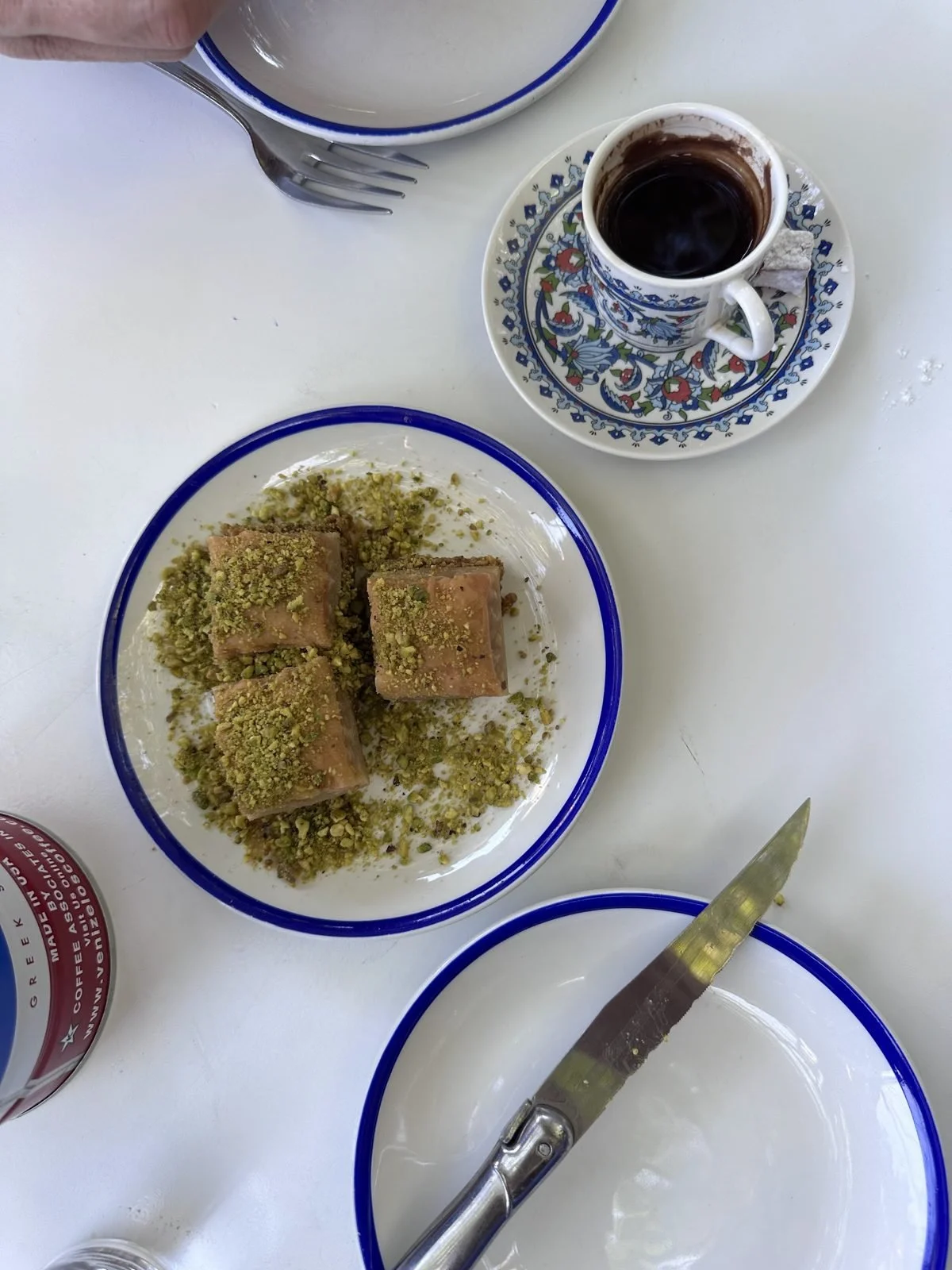 Coffee and pistachio pastries on blue rimmed plates
