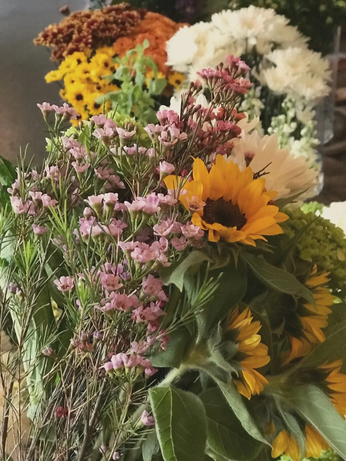 A loose bouquet of sunflowers and wildflowers