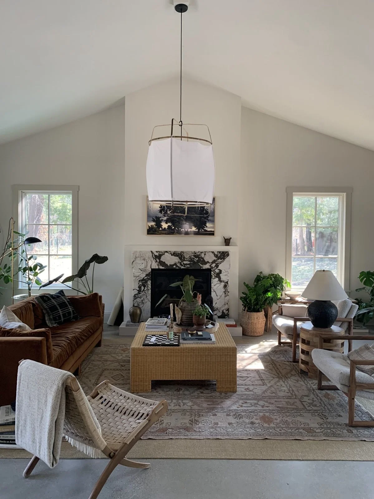 A bright living room with a vaulted ceiling and fireplace