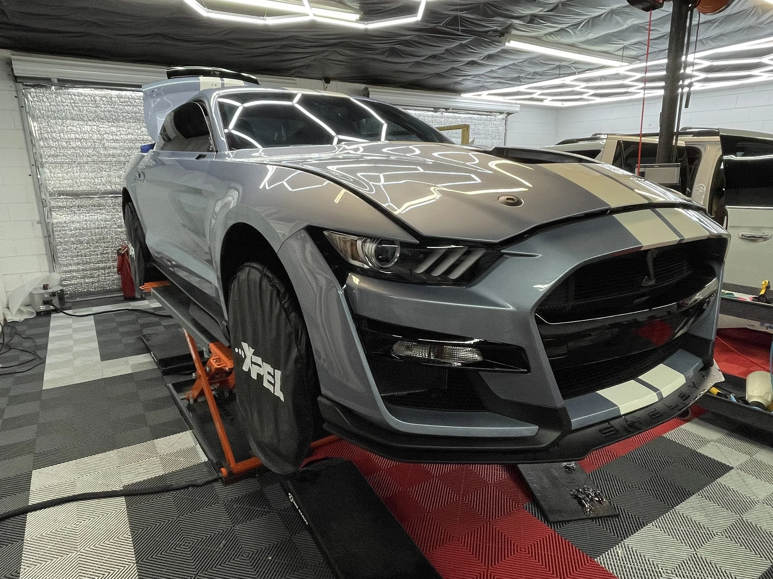 Paint protection film being installed on a gray performance car