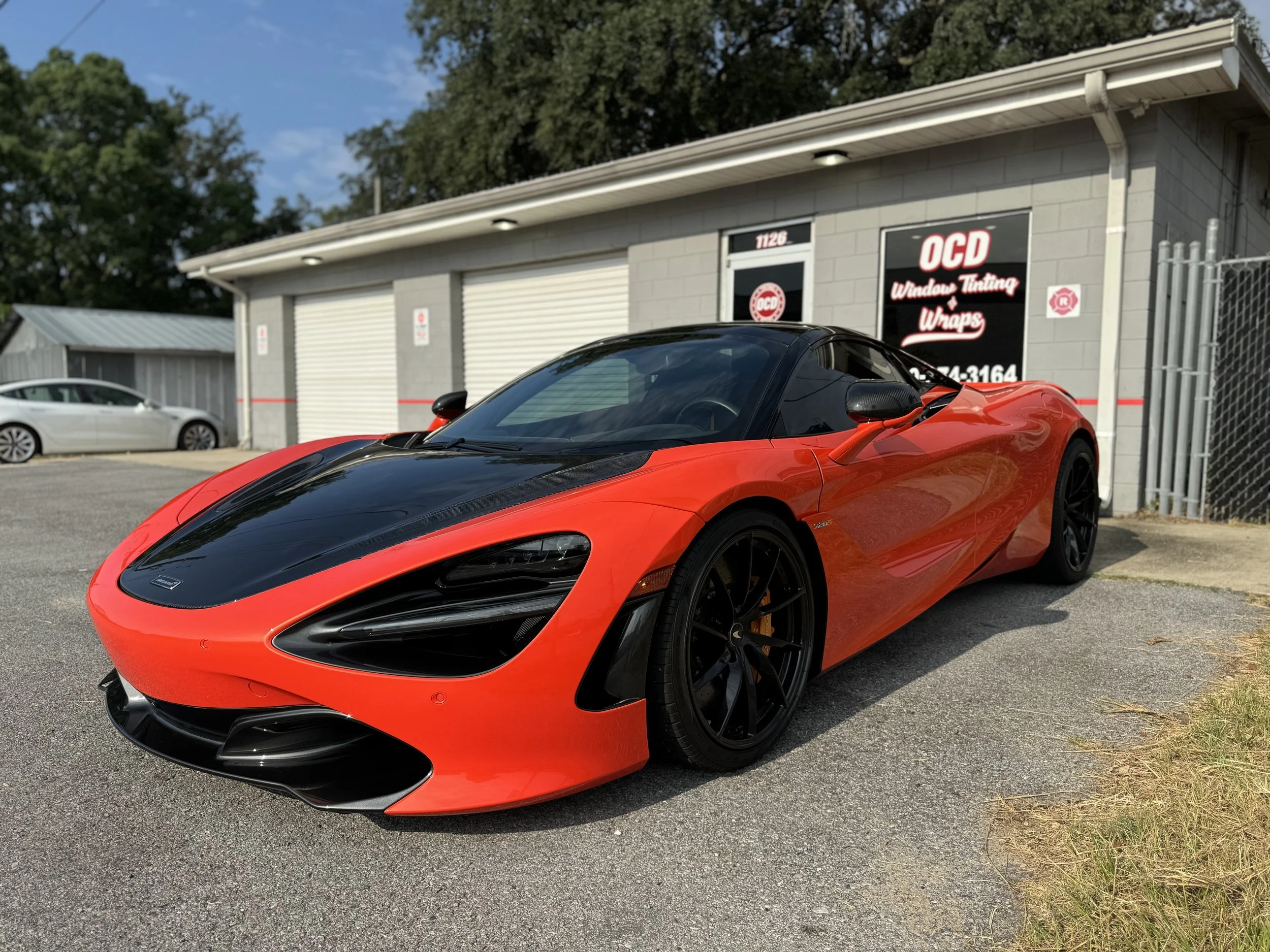 Red performance car outside OCD after window tint service