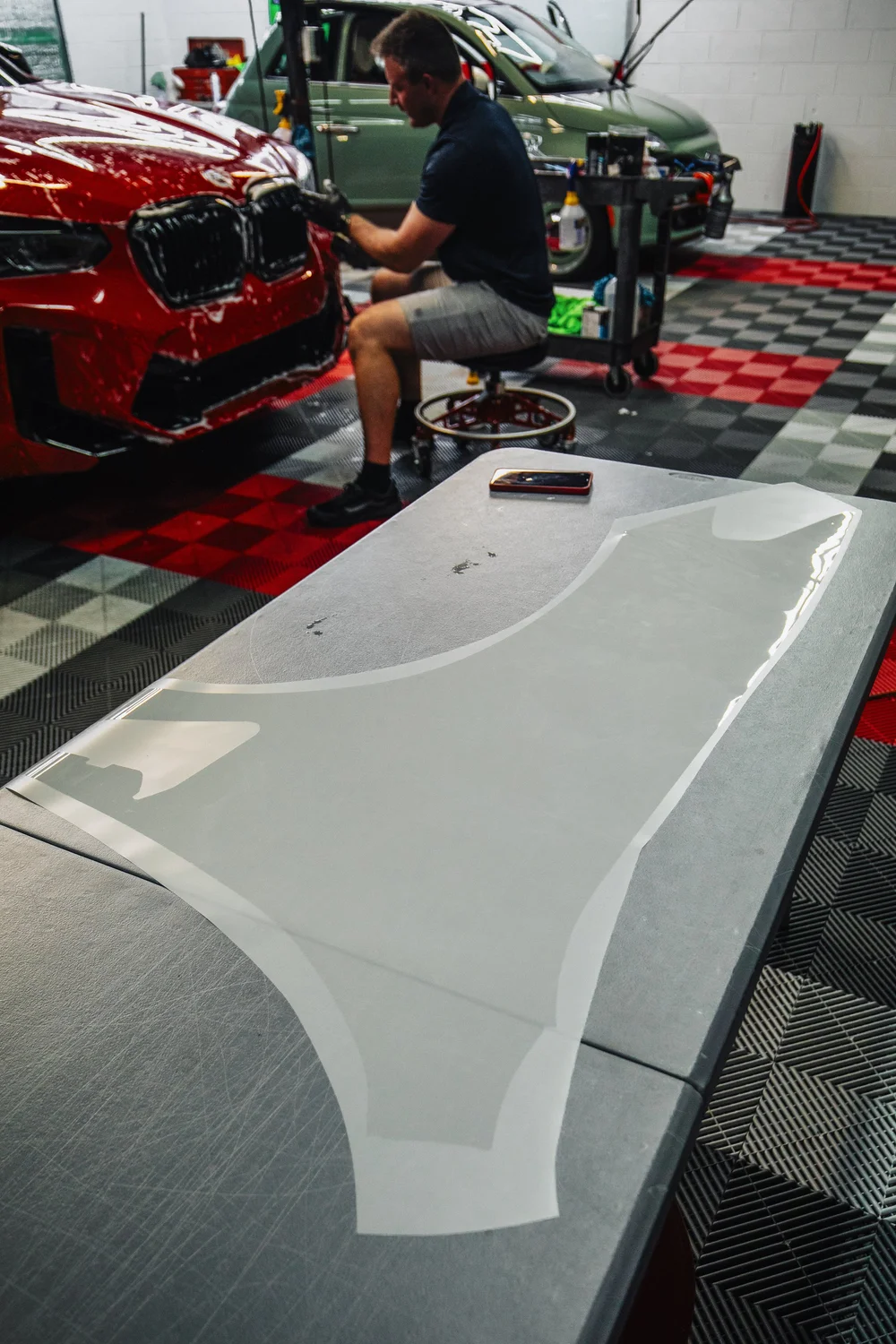 OCD installer applying paint protection film in the Fort Walton Beach shop