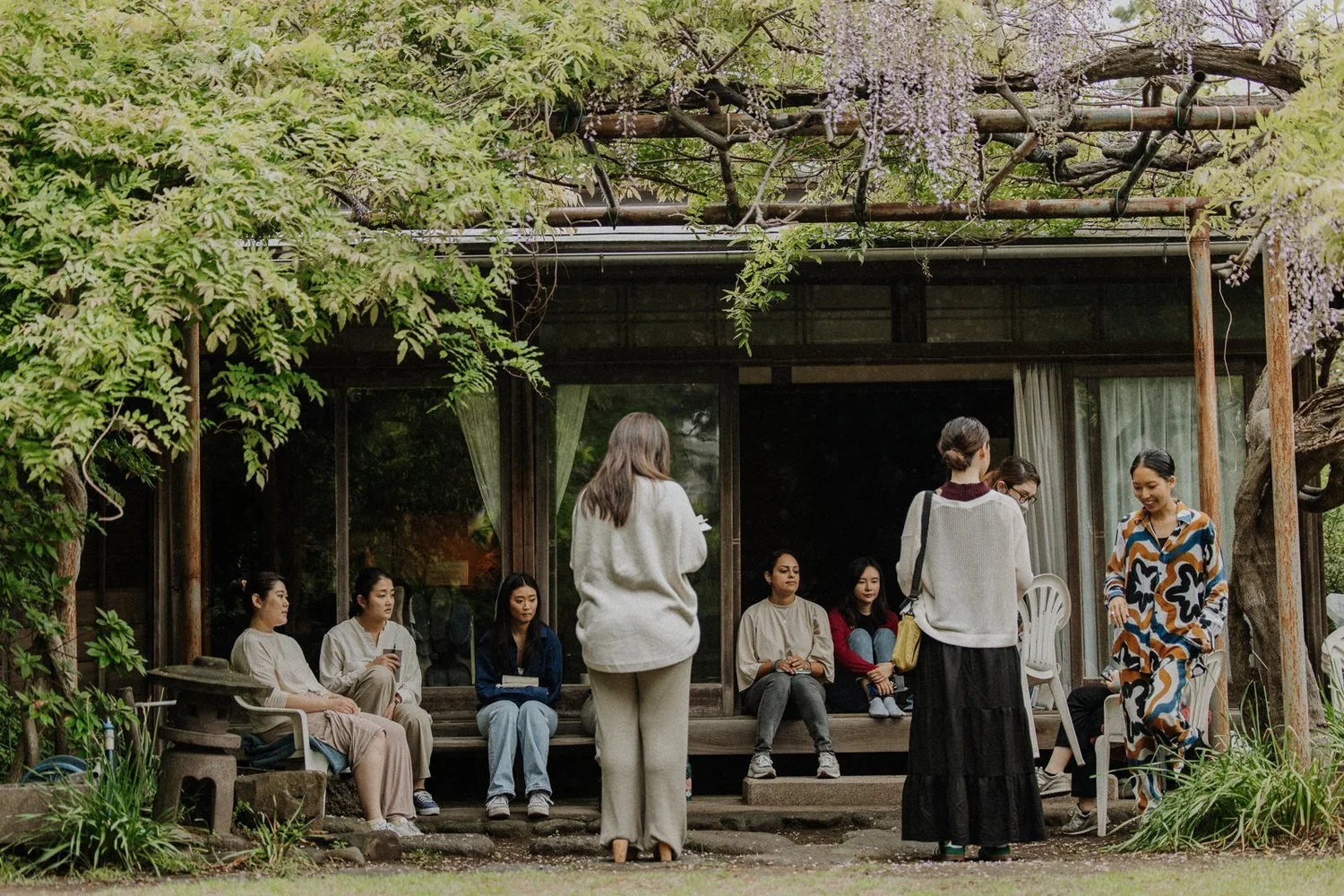 Retreat participants gathered on the veranda of a traditional Japanese house under wisteria
