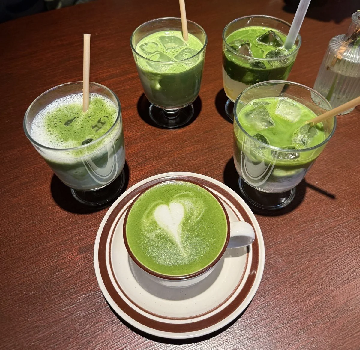Matcha lattes and iced matcha drinks on a wooden table