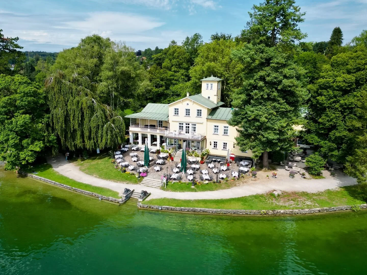 Das Midgardhaus von der Seeseite mit gedeckter Terrasse am Ufer