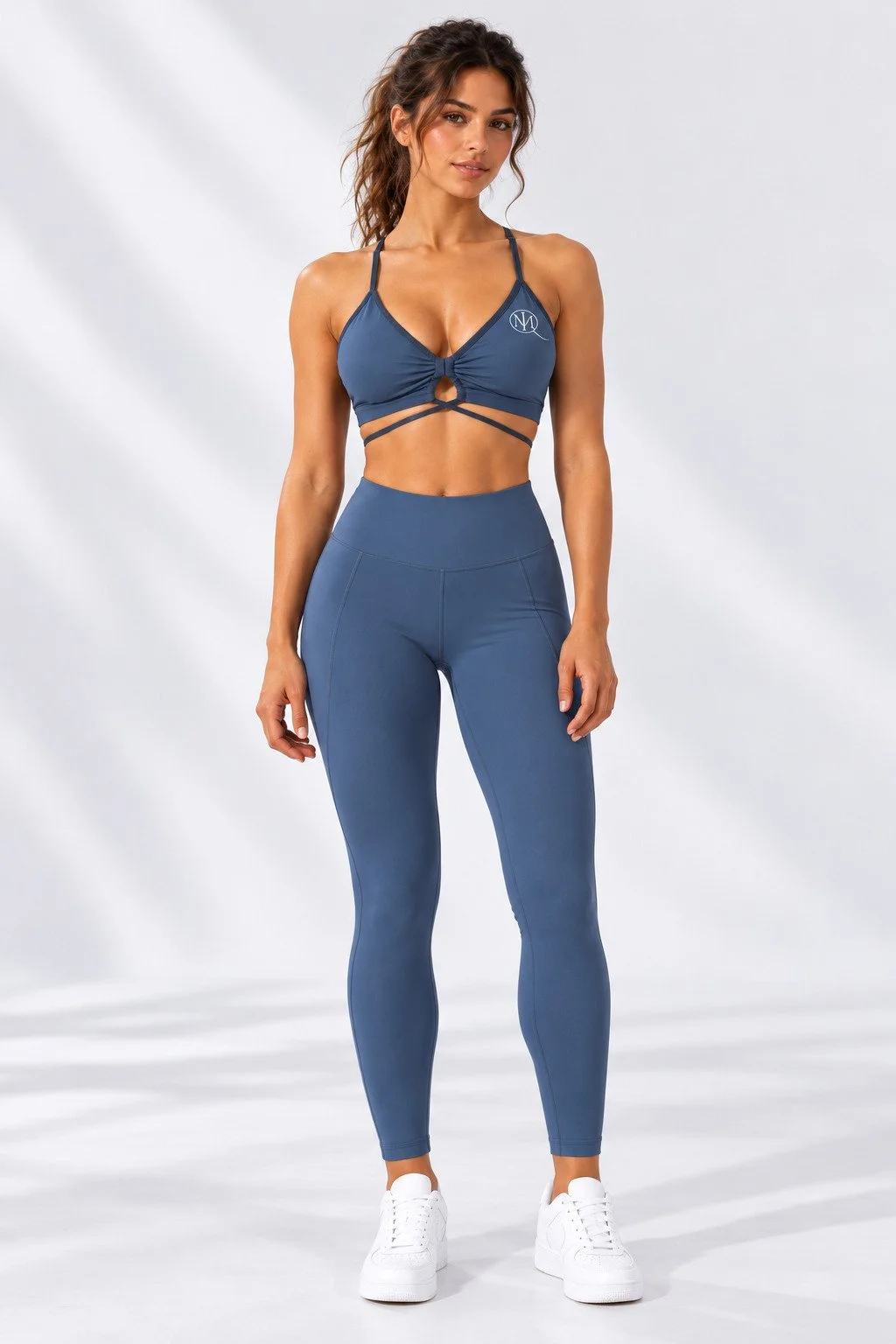 Full-body front view of a model in slate-blue MIQ leggings and sports bra