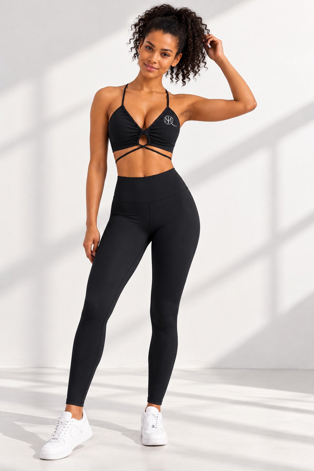 Full-body portrait of model in black MIQ coordinated sports bra and leggings