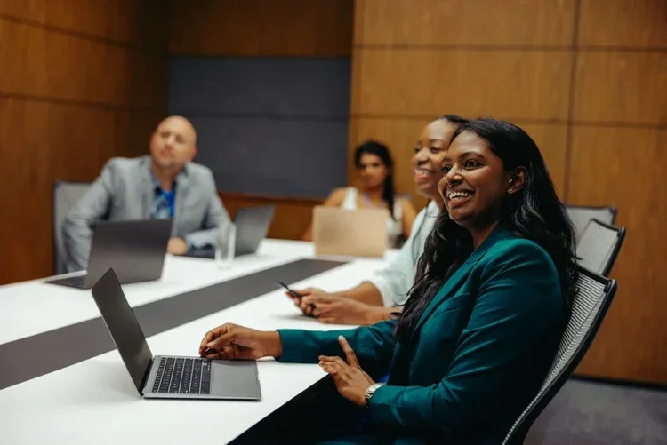 A woman contributing to a boardroom discussion with colleagues