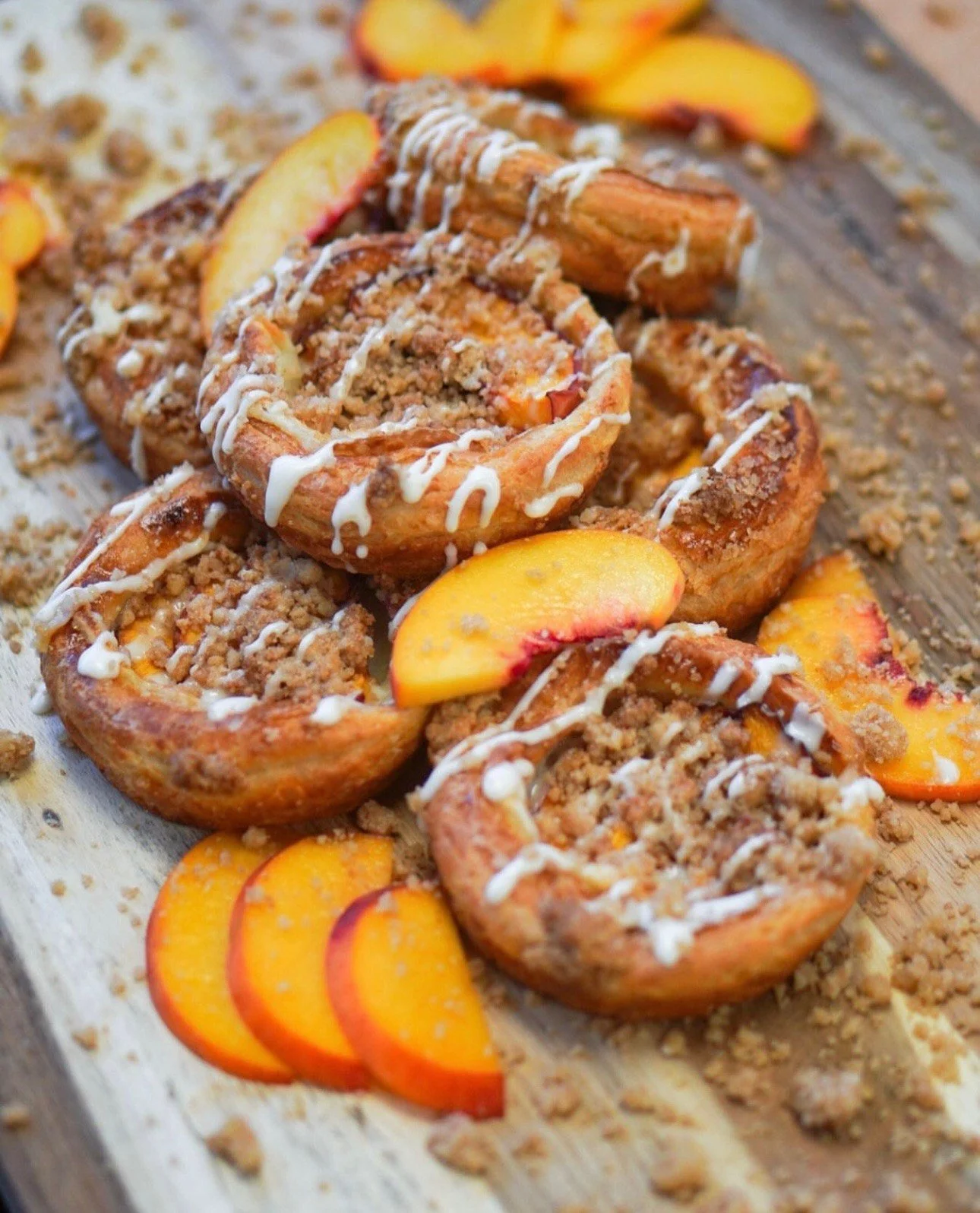 Pastries with peach slices and a light icing drizzle