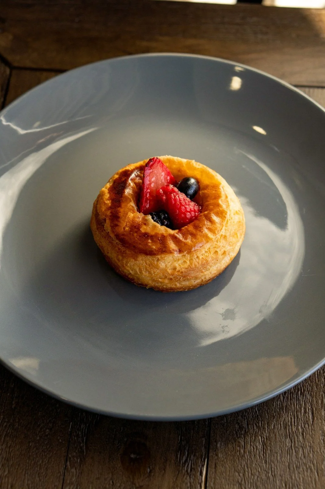 A berry-topped pastry on a plate