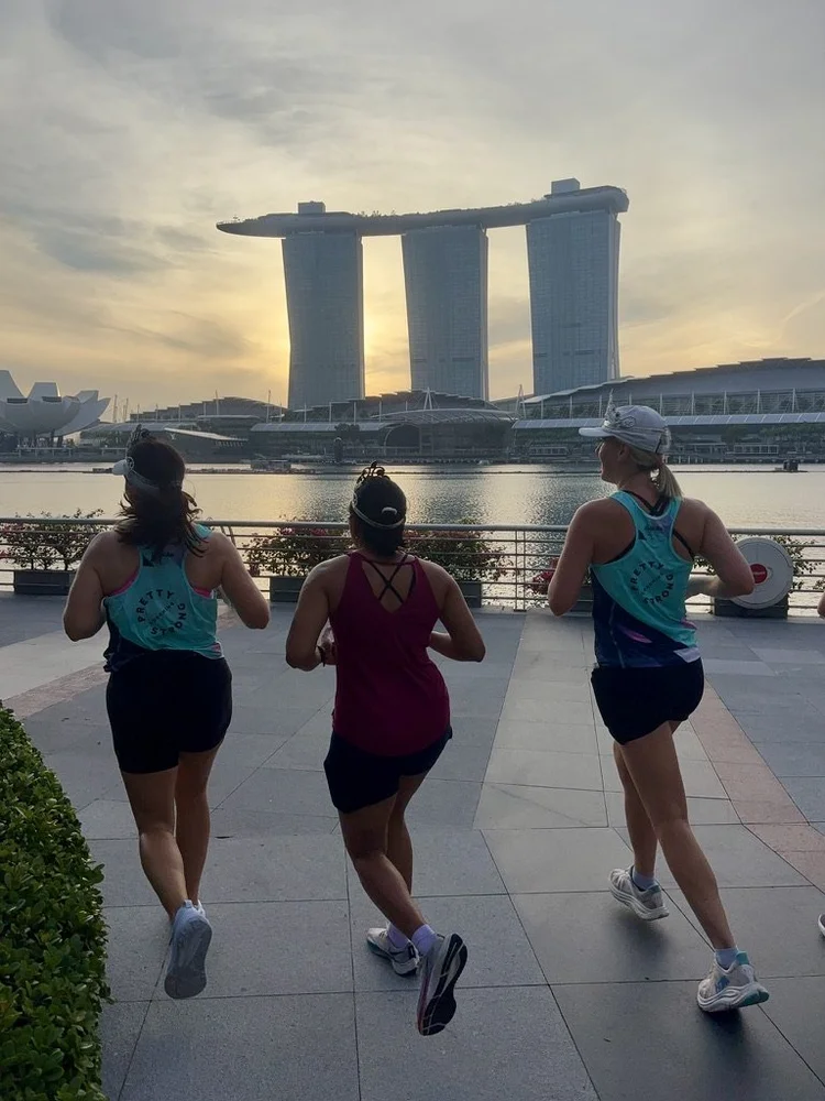 Three Pretty Strong athletes running past Marina Bay Sands, Singapore
