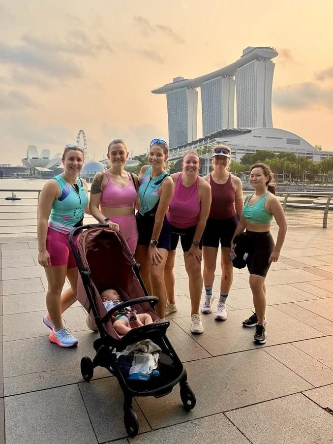 Six Pretty Strong women and a baby in a pram in front of Marina Bay Sands after a sunrise run