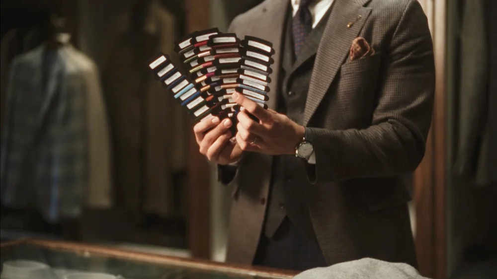 A suited subject holding fabric swatches in an earlier Aaron Daniel Films production