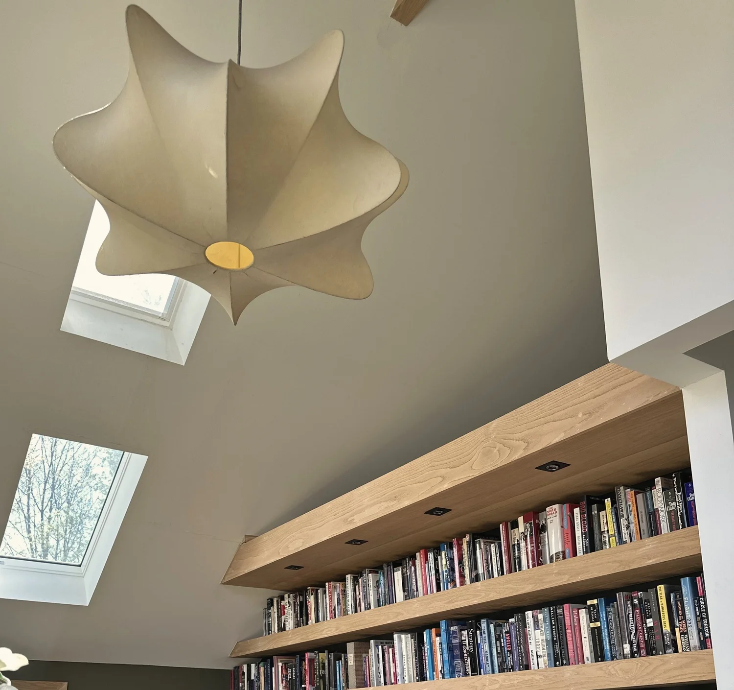 The library under the roof at the Bellevue Manor, with painted brick, new skylights and a long walnut bookshelf