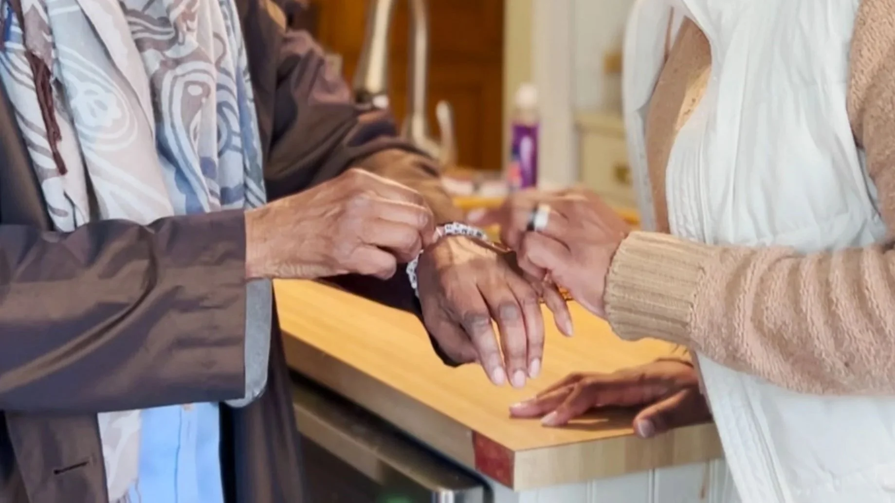Lareatha Payne points to a bracelet reading Woman of Faith during a conversation inside the Sister2Sister facility