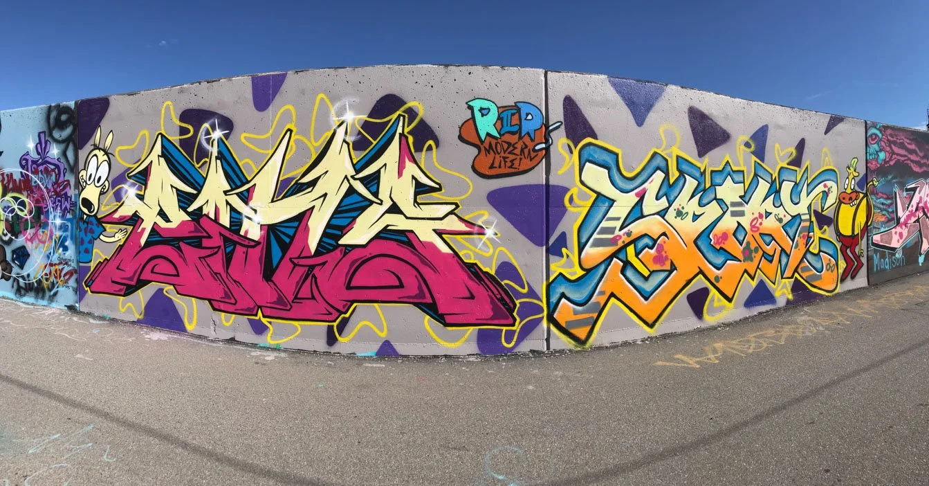 Panoramic Mural Mile wall with large graffiti letter pieces and cartoon figures