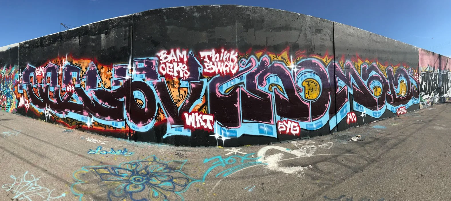 Panoramic graffiti lettering in black, blue, pink and orange across the Mural Mile