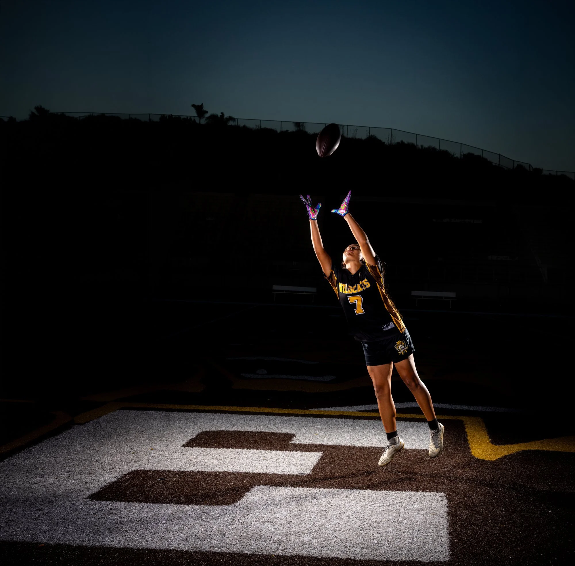 El Camino Wildcats athlete making a catch on the field at dusk