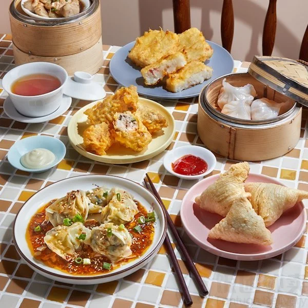 Overhead spread of dim sum: dumplings, turnip cake, shrimp toast and tea