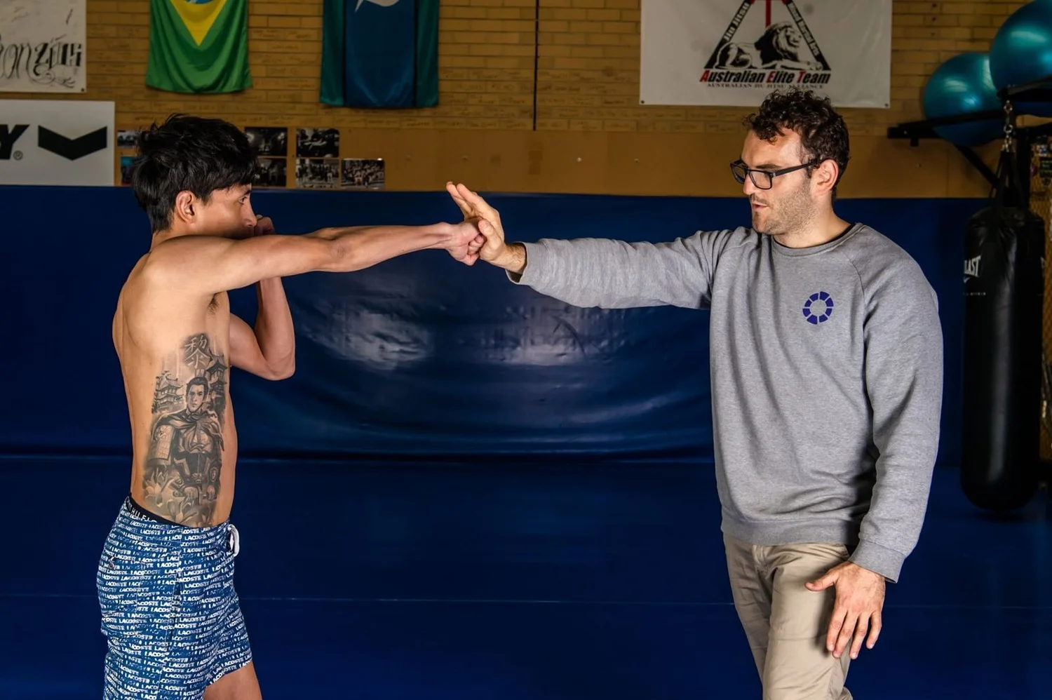 Dr Luke Smith working through a hand-speed striking drill with an athlete on the mats