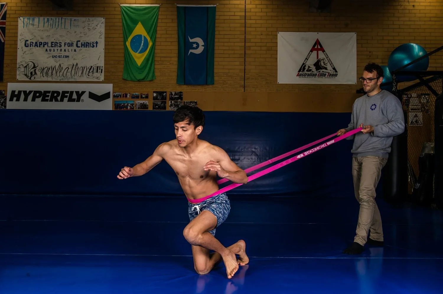 Athlete working through a resisted lunge drill with Dr Luke Smith on the mats