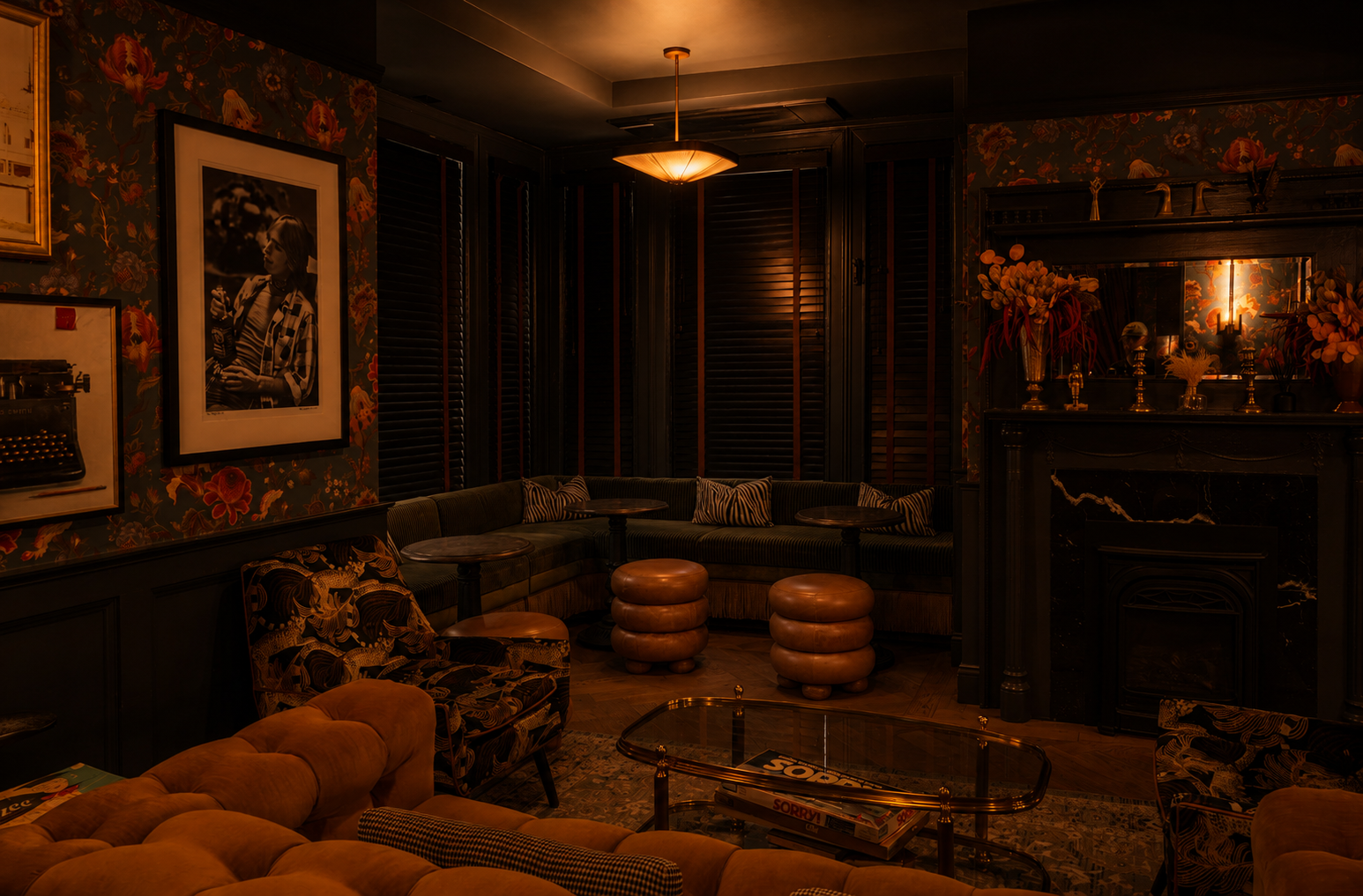 Ember Lounge at Left Door with floral wallpaper, layered sofas and armchairs, small tables, and a fireplace. Photo credit: @lifeof_robbie.