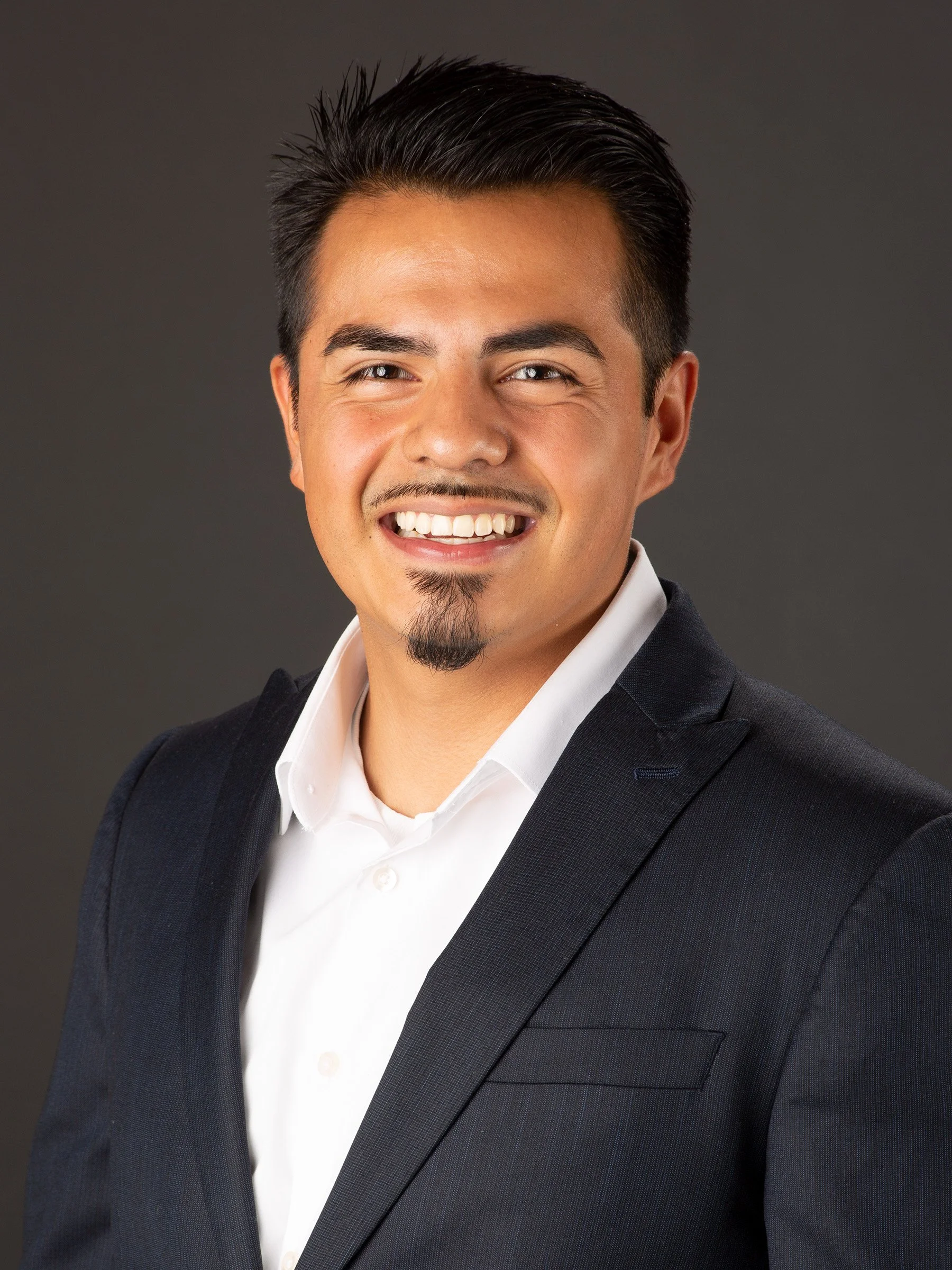 Adrian Mota, founder of AIM Senior Services, wearing a dark suit and white shirt