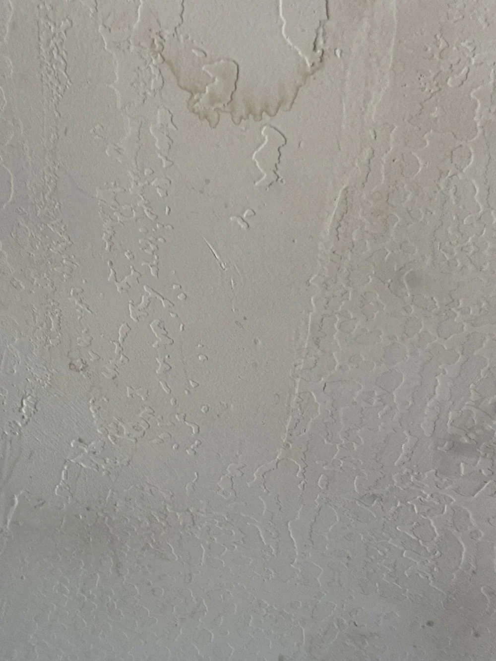 Water-stained, cracked textured wall before drywall repair in Incline Village