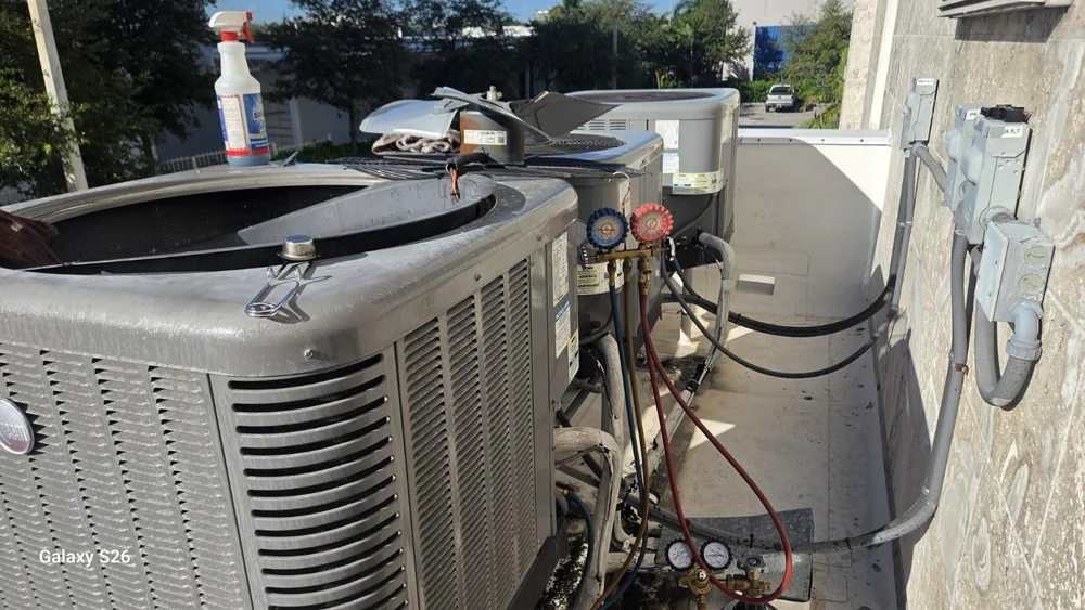 Service gauges connected to an outdoor AC unit during refrigerant leak repair in Doral