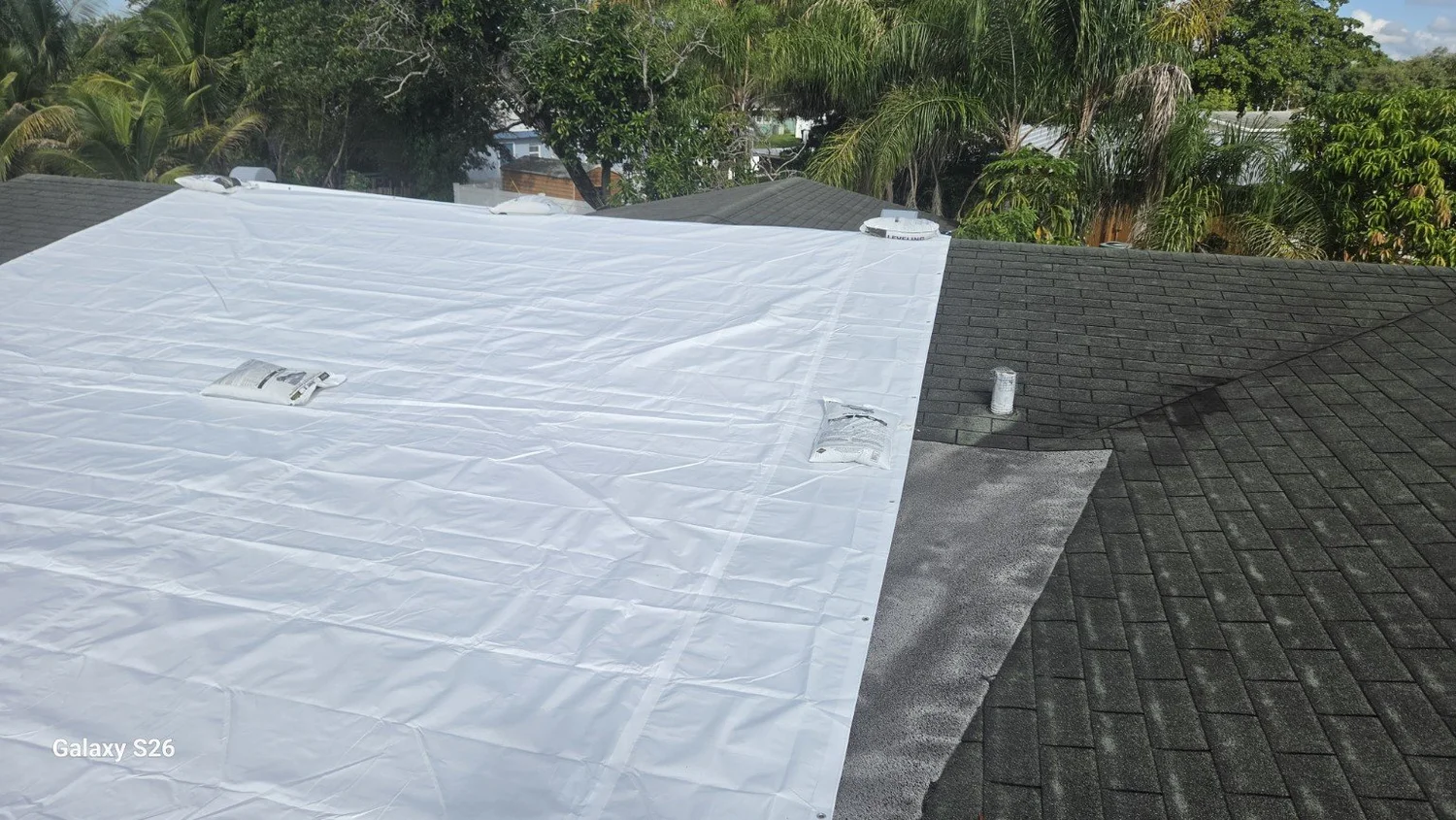 Temporary white roof tarp installed at a Fort Lauderdale roof-leak project