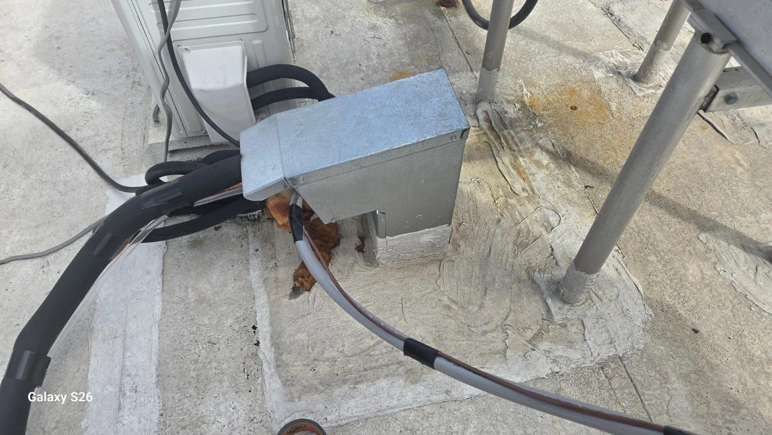 Metal roof gooseneck beside AC refrigerant lines