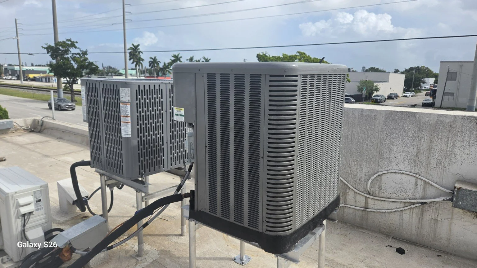 Outdoor AC condenser on a rooftop equipment rack in Wilton Manors