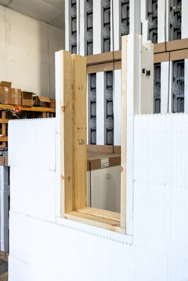 Foam window buck capped with lumber, set into a wall of white ICF blocks