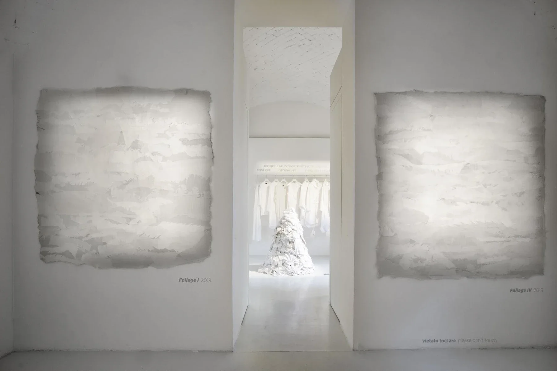Felted textile artworks frame a doorway into the WASTE NO MORE exhibition at Rossana Orlandi in Milan.