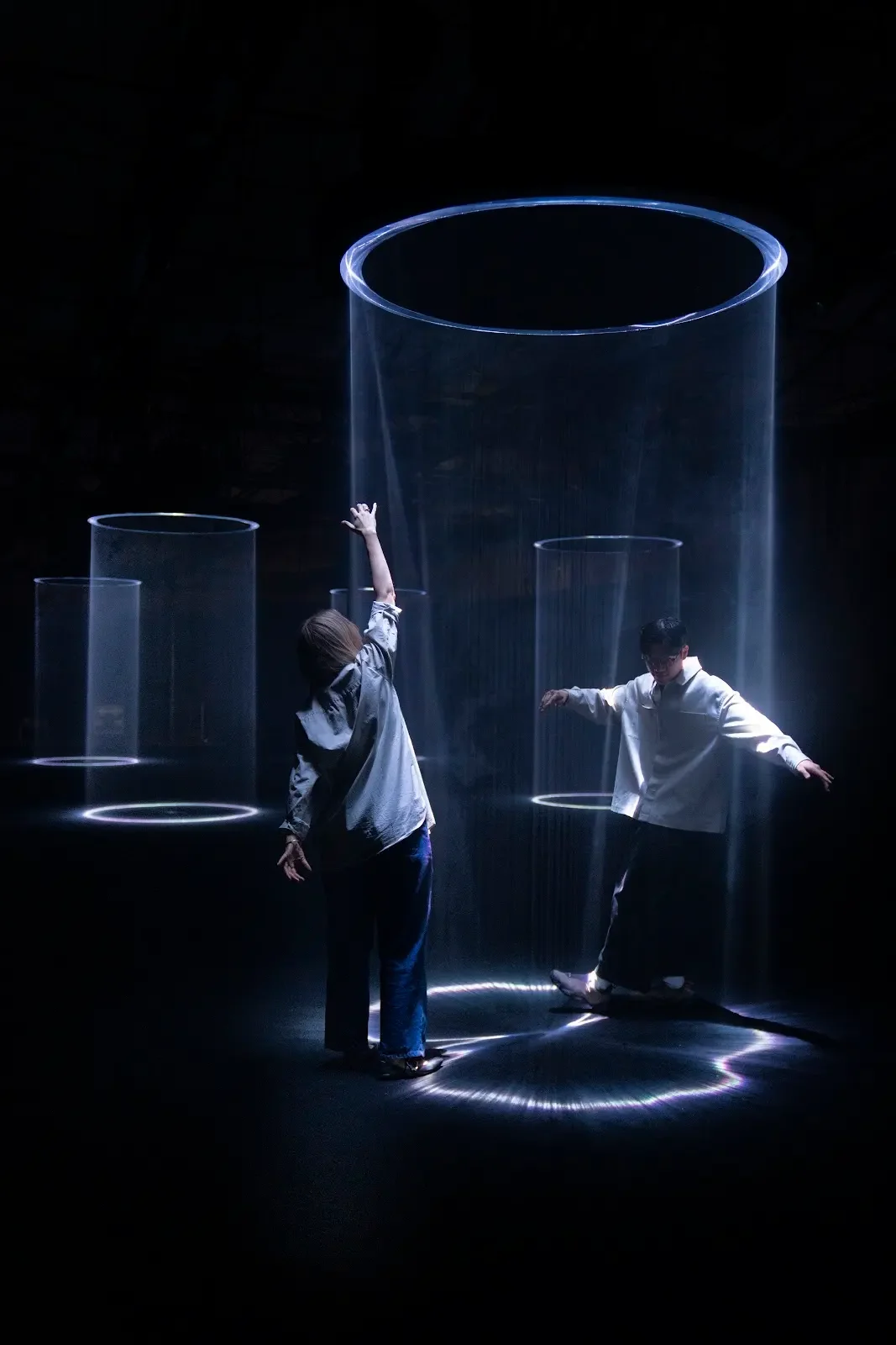 Visitors interacting with columns of light in Google's Making the Invisible Visible exhibition in Milan.