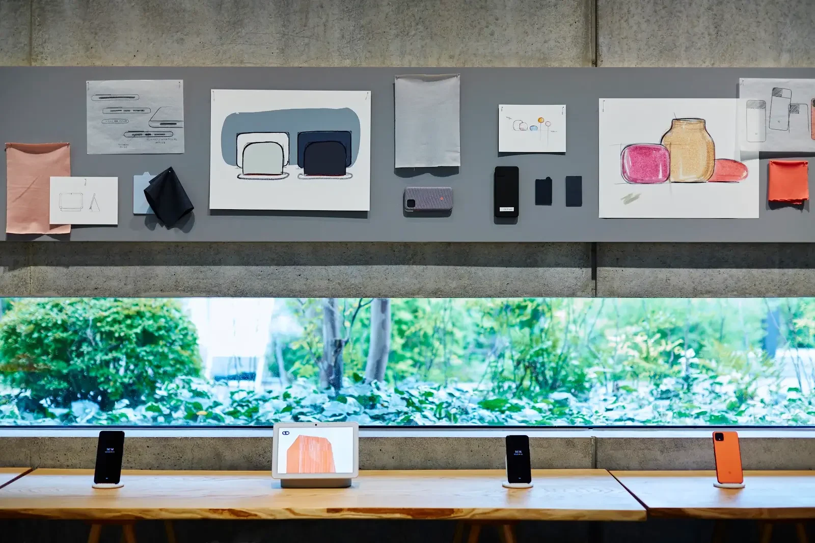 Design sketches and Google devices displayed along a window at the comma exhibition in Tokyo.
