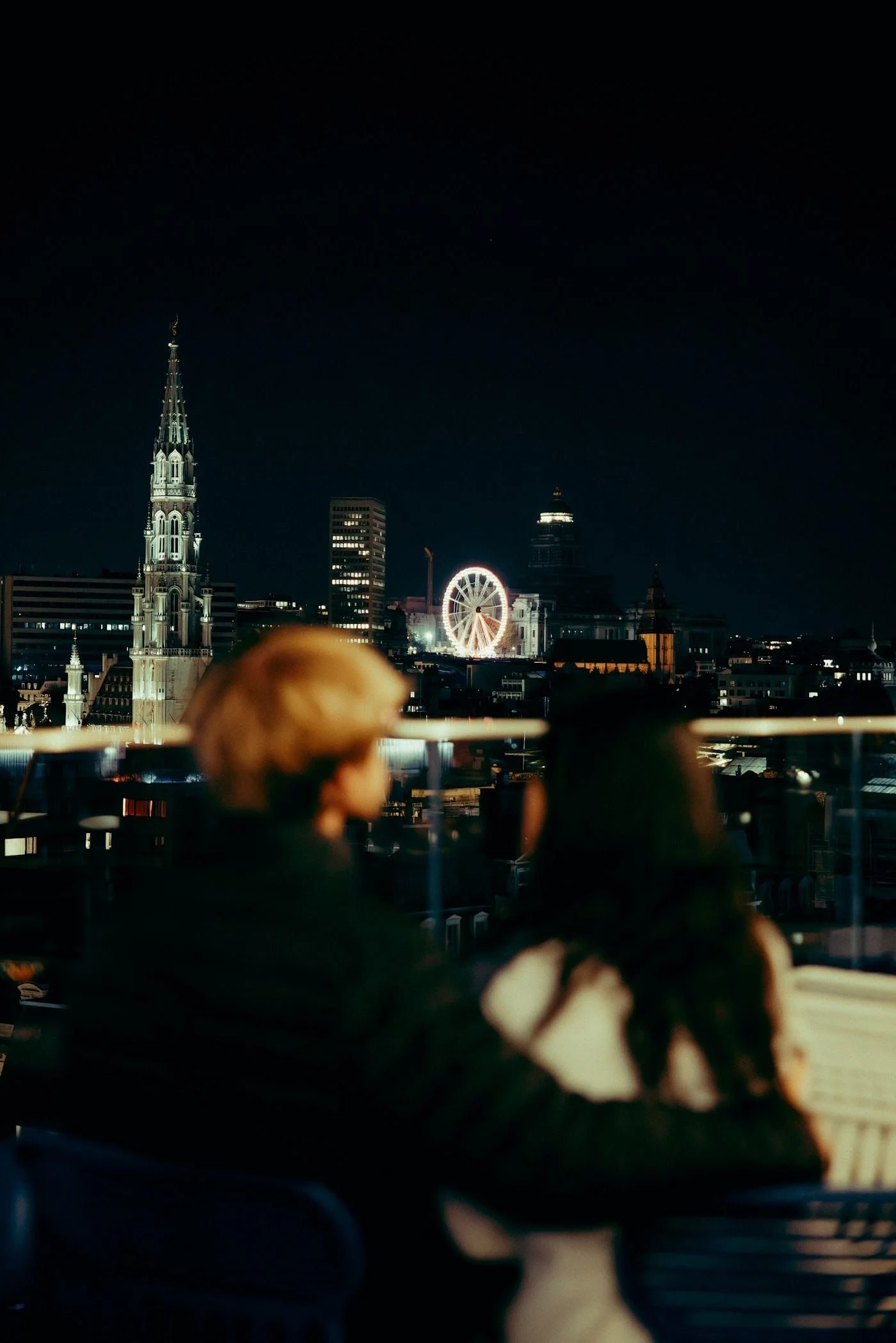 A couple taking in the view over Brussels and the Ferris wheel
