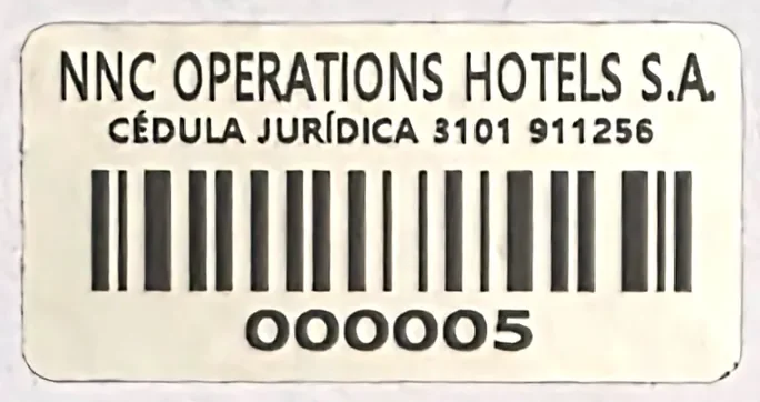 Etiqueta de aluminio para activo fijo de NNC Operations Hotels con cédula jurídica y código de barras
