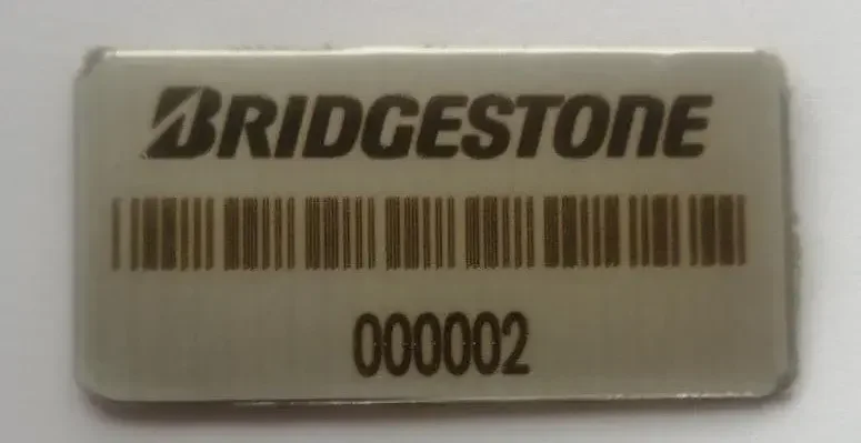 Placa rectangular de acero inoxidable de Bridgestone con código de barras y número 000002