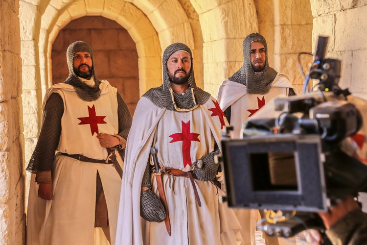 Costumed medieval cast and a production camera on set in Morocco.