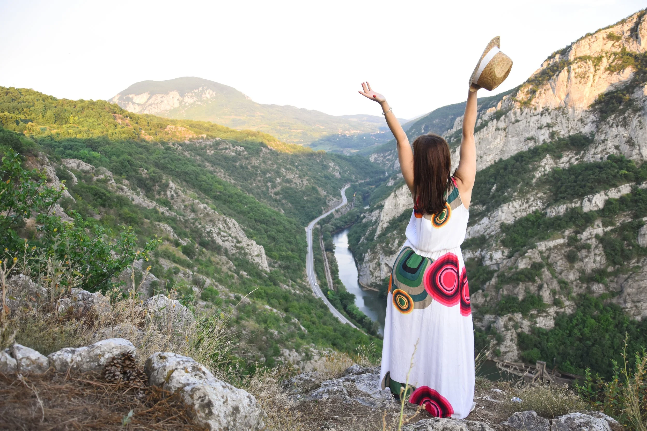 Woman standing with arms open at dawn in the Finger Lakes hills near Ithaca, NY