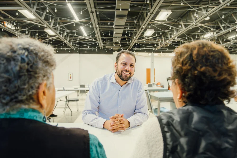 Abdelnasser Rashid listening to residents at a community center