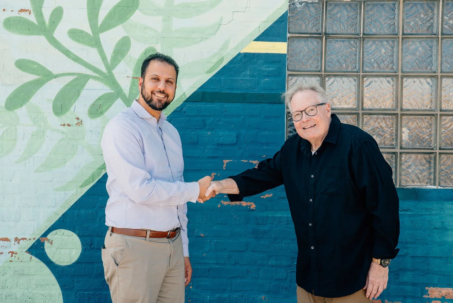 Abdelnasser Rashid shaking hands with a resident