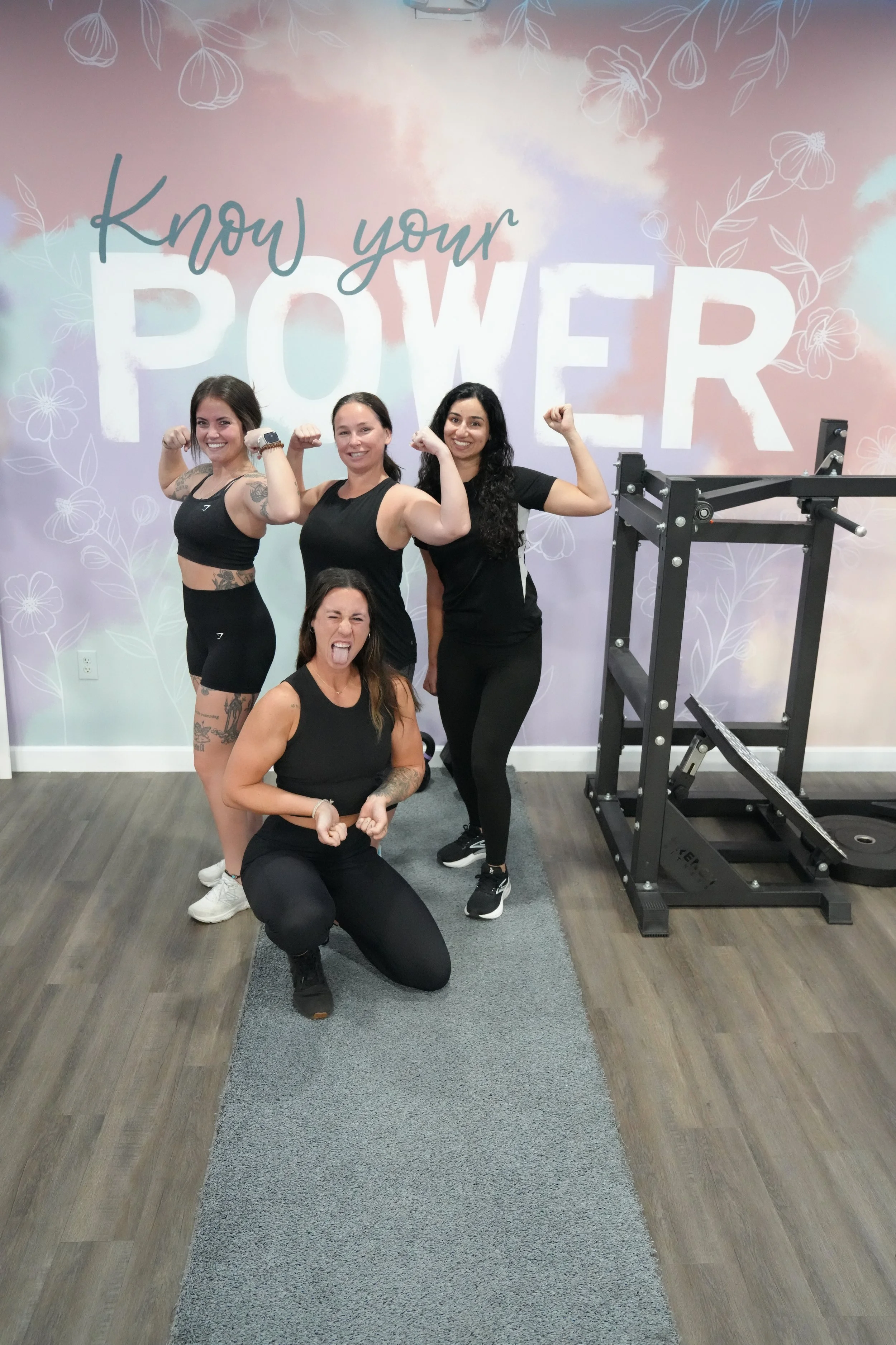 Group flex in front of Know Your Power wall celebrating progress