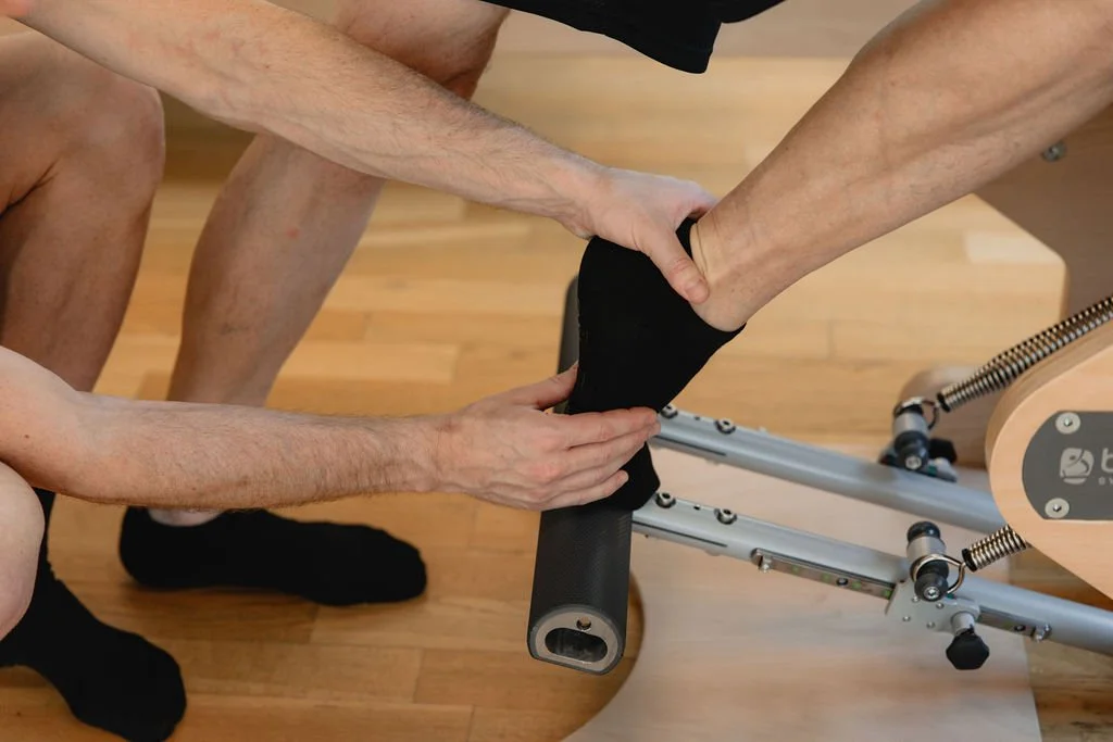 Hands guiding foot alignment on the Wunda Chair during private training