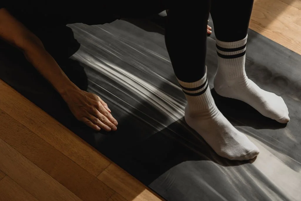 Close-up of hands and feet on the mat during Pilates Mat practice