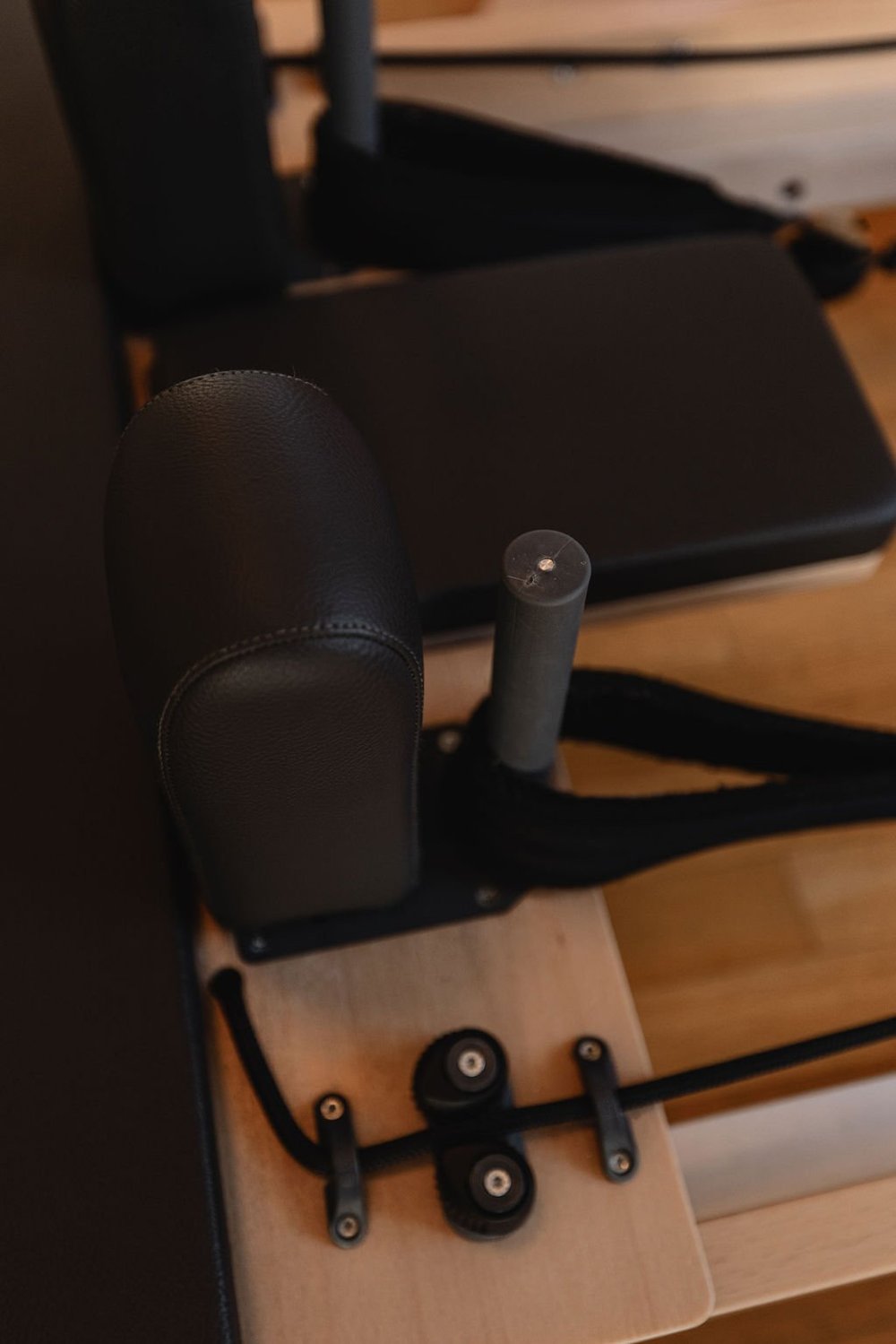 Reformer shoulder rests, headrest and straps in warm studio light