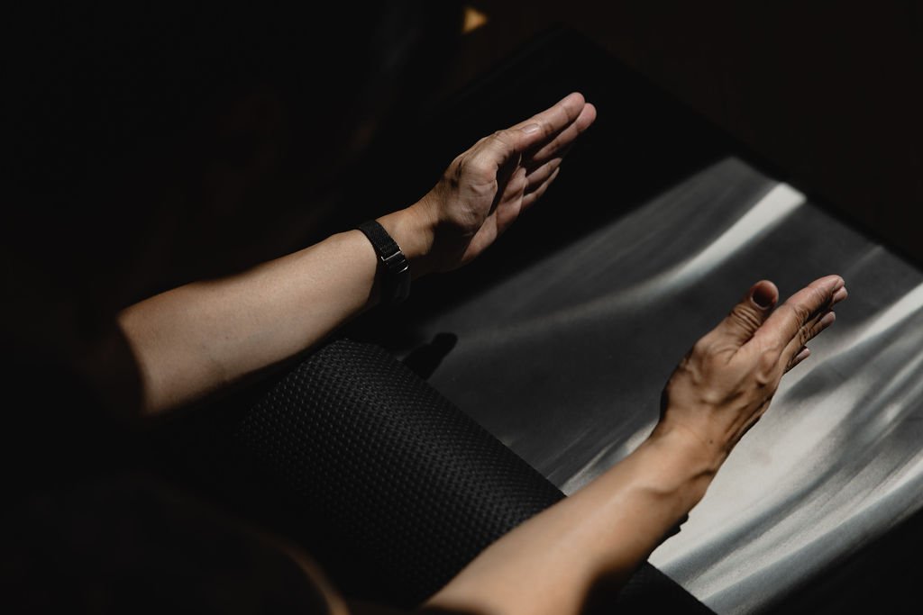 Hands moving with control during a mat-based Pilates exercise